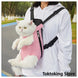 Pink grid cat carrier backpack on city street with Glimbo and Glimby mascots - urban adventure